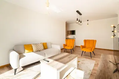 a living room with a white couch and orange chairs at GuestReady- Charming Condo with Pool in Caniço in Caniço