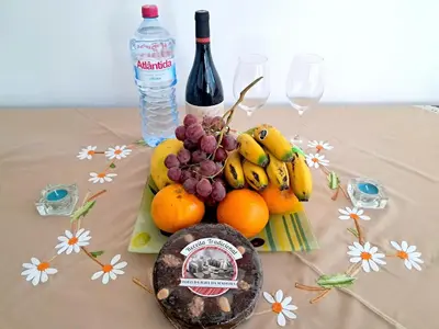 a table with a bottle of wine and fruit on it at Casa Martins in São Vicente