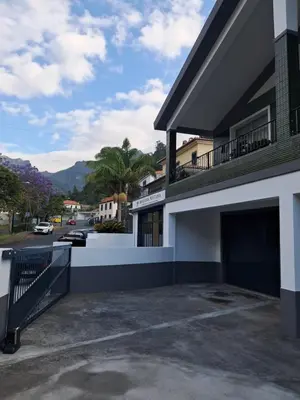 a building with a parking lot next to a street at Casa Martins in São Vicente