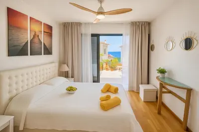 a bedroom with a white bed with yellow towels on it at Varandas do Sol - Private Sun Terrace close to Natural Pools & Praia Formosa in Funchal