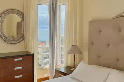 a bedroom with a bed and a mirror and a window at Perla do Oceano - Funchal Sea View with XL Terrace in Funchal