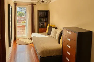 a living room with a couch and a book shelf at Perla do Oceano - Funchal Sea View with XL Terrace in Funchal