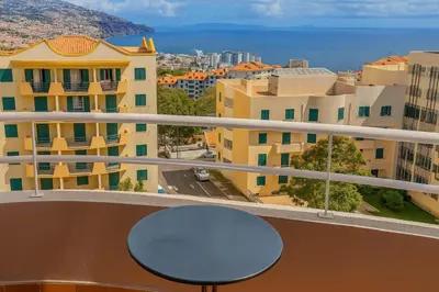 a balcony with a table and views of the city at Perla do Oceano - Funchal Sea View with XL Terrace in Funchal