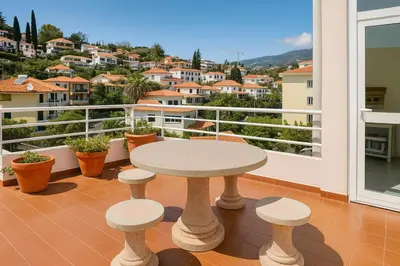 a patio with a table and stools on a balcony at Perla do Oceano - Funchal Sea View with XL Terrace in Funchal