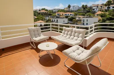 a balcony with two chairs and a table at Perla do Oceano - Funchal Sea View with XL Terrace in Funchal