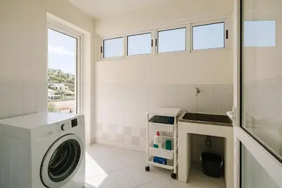a laundry room with a washing machine and a window at Perla do Oceano - Funchal Sea View with XL Terrace in Funchal