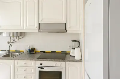 a kitchen with white cabinets and a stove top oven at Perla do Oceano - Funchal Sea View with XL Terrace in Funchal