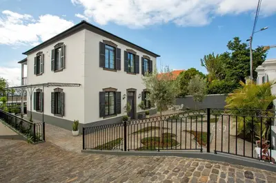 a kitchen and dining room with a wooden table and chairs at Vila Francisco in Funchal