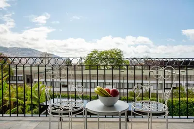 a bowl of fruit sitting on a wooden bench on a balcony at Vila Francisco in Funchal