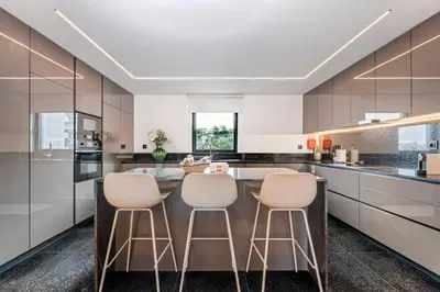 a kitchen with a large island with four stools at Panoramic Bay and Sea Views - Luxury 3-Bed Flat in Funchal