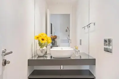 a bathroom with a sink and a vase of flowers on a counter at Panoramic Bay and Sea Views - Luxury 3-Bed Flat in Funchal