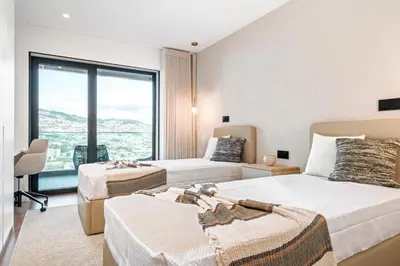 a hotel room with two beds and a large window at Panoramic Bay and Sea Views - Luxury 3-Bed Flat in Funchal