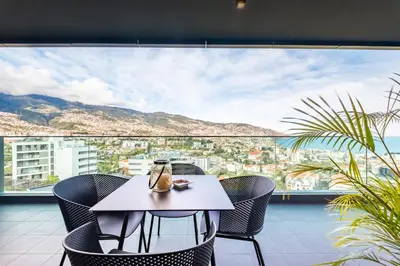 a table and chairs on a balcony with a view at Panoramic Bay and Sea Views - Luxury 3-Bed Flat in Funchal