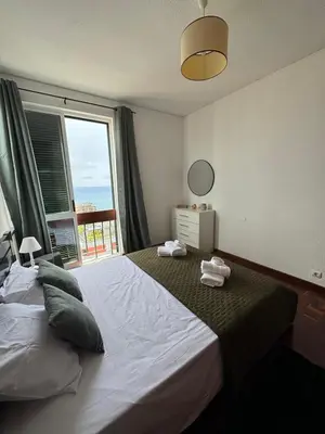 a bedroom with a large bed with a large window at América Apartment Holiday in Funchal