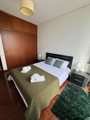 a hotel room with two beds and a green rug at América Apartment Holiday in Funchal