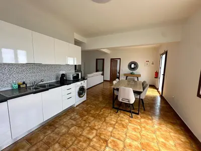 a kitchen with white cabinets and a table and chairs at Anita & Leonel's House A in Gaula