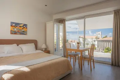 a bedroom with a bed and a table and a window at Madeira Rooftop Studio, Ocean & City View in Funchal