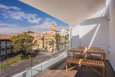 a balcony with a bench and a view of a city at Madeira Rooftop Studio, Ocean & City View in Funchal