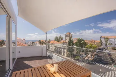 a balcony with a table and a view of the city at Madeira Rooftop Studio, Ocean & City View in Funchal