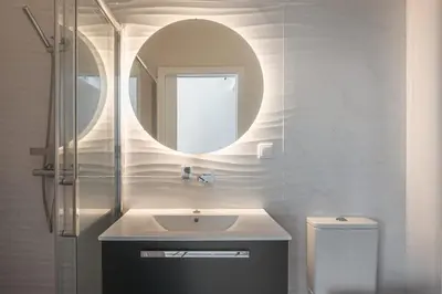 a bathroom with a sink and a mirror and a toilet at Madeira Rooftop Studio, Ocean & City View in Funchal
