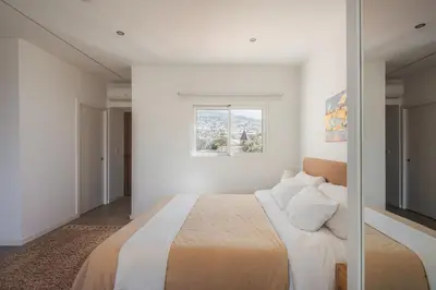 a bedroom with a large bed with a window at Madeira Rooftop Studio, Ocean & City View in Funchal