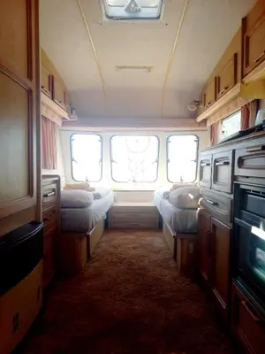 a small room with beds in the back of an rv at Michas caravan for 2 See the herd of horses from your bed in Barão de São João