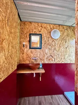 a bathroom with a sink and a red wall at Michas caravan for 2 See the herd of horses from your bed in Barão de São João