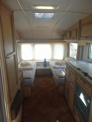 a small room with three beds in an rv at Michas caravan for 2 See the herd of horses from your bed in Barão de São João