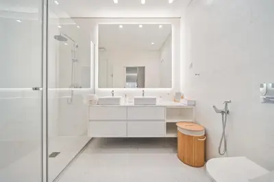 a white bathroom with two sinks and a shower at In-Town Residences in Funchal
