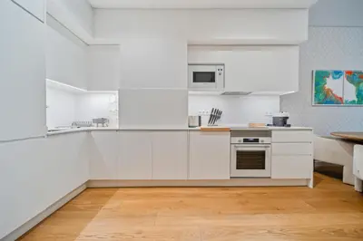 a white kitchen with white cabinets and a stove at In-Town Residences in Funchal