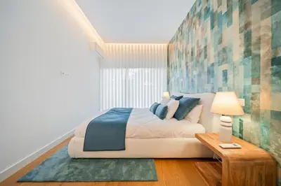 a bedroom with a large bed and a table at In-Town Residences in Funchal