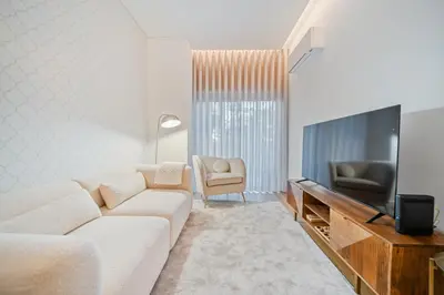 a living room with a white couch and a television at In-Town Residences in Funchal