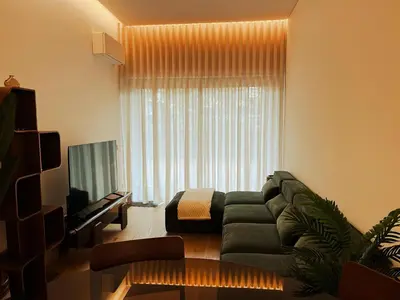 a living room with a green couch and a television at In-Town Residences in Funchal