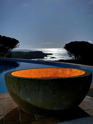 a large stone planter sitting next to a pool at Casa da Ingrina in Raposeira