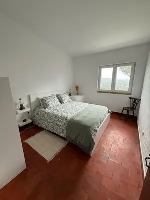 a white bedroom with a bed and a window at Casa da Ingrina in Raposeira