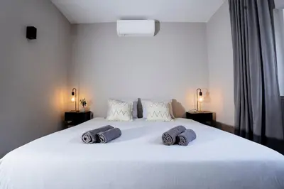 a bedroom with a large white bed with towels on it at Orteá Sea Breeze in Budens