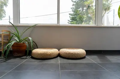 two stools sitting in a room with two windows at Orteá Sea Breeze in Budens