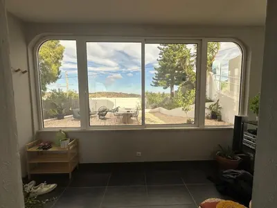 a room with a large window with a view of a patio at Orteá Sea Breeze in Budens