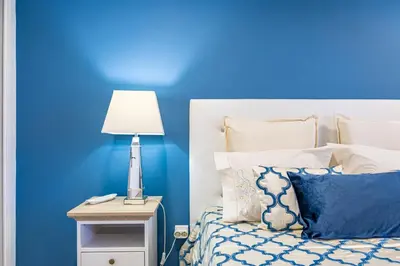a blue bedroom with a bed with a blue wall at Casa da Fonte by YOUR KEY - 1st floor house in Ribeira Brava