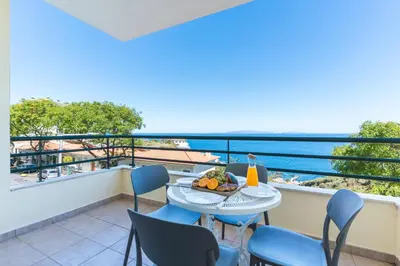 a balcony with a table and chairs and the ocean at My Home Reis Magos by Atlantic Holiday in Caniço