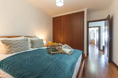 a bedroom with a large bed and a table at My Home Reis Magos by Atlantic Holiday in Caniço