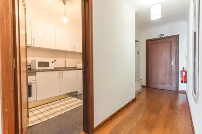 a kitchen with white cabinets and a wooden door at My Home Reis Magos by Atlantic Holiday in Caniço
