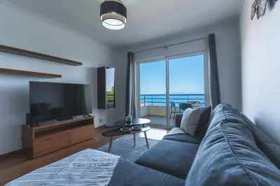 a living room with a blue couch and a television at My Home Reis Magos by Atlantic Holiday in Caniço