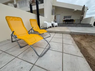 two yellow chairs sitting on a patio in front of a house at Villas Sossego in Porto Santo