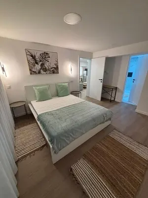 a bedroom with a large bed with green pillows at Villas Sossego in Porto Santo