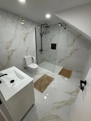 a white bathroom with a shower and a toilet at Villas Sossego in Porto Santo