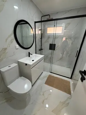 a white bathroom with a toilet and a shower at Villas Sossego in Porto Santo