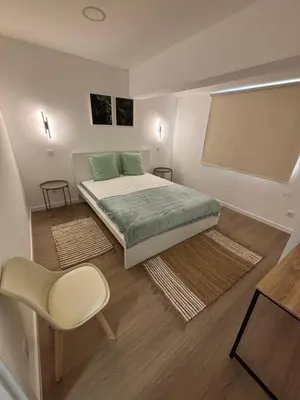 a small bedroom with a bed and a chair at Villas Sossego in Porto Santo