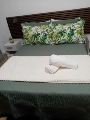 a bed with a towel on top of it at Vivenda Silva in Seixal