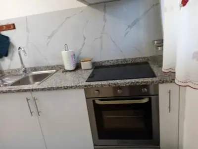 a kitchen counter with a stove and a sink at Vivenda Silva in Seixal